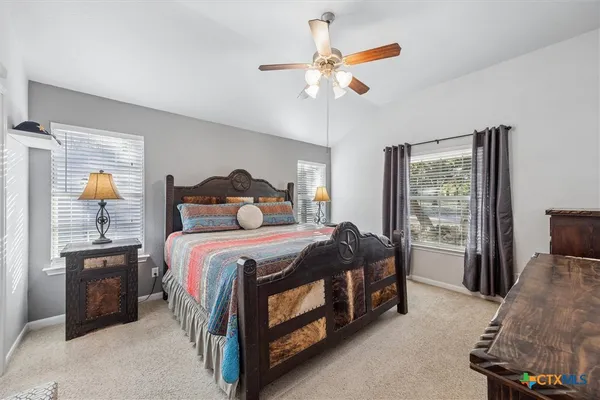 a bedroom with a bed chandelier and a window
