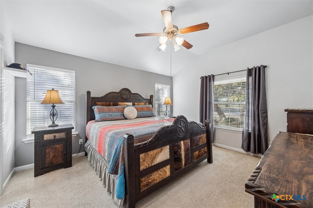 1328 Cottonwood Road Fischer, TX 78623 - Photo 19 of 35 a bedroom with a bed chandelier and a window