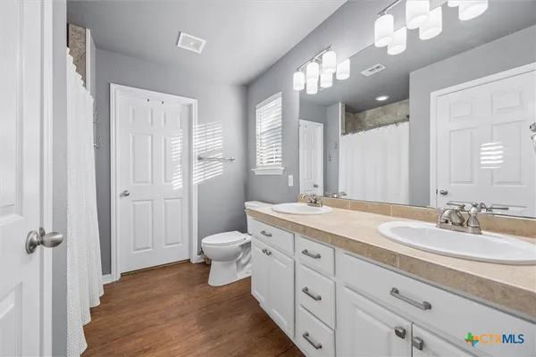 a spacious bathroom with a granite countertop sink toilet and shower