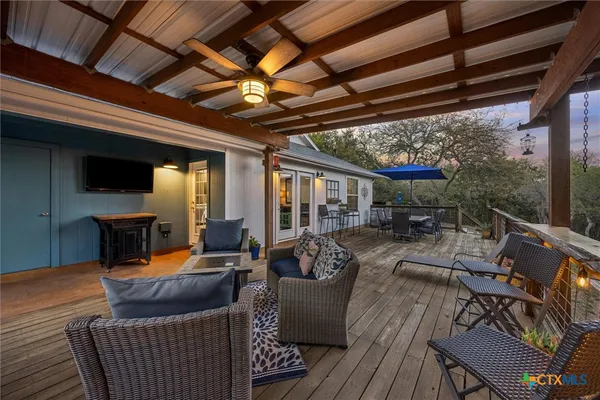 a view of a patio with couches chairs dining table and chairs with wooden floor