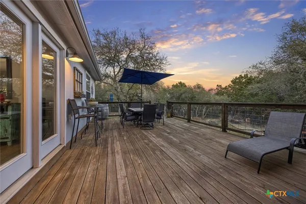a view of a roof deck with table and chairs with wooden floor and fence