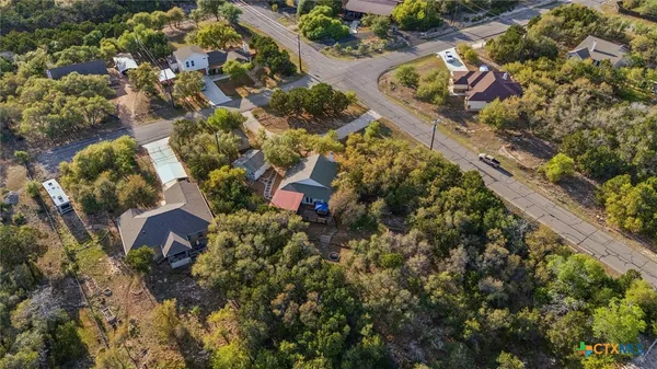 an aerial view of a house with a yard and large trees