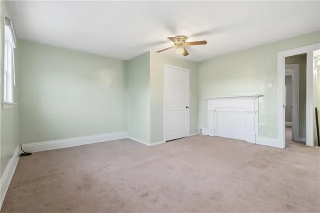 an empty room with a chandelier fan and closet