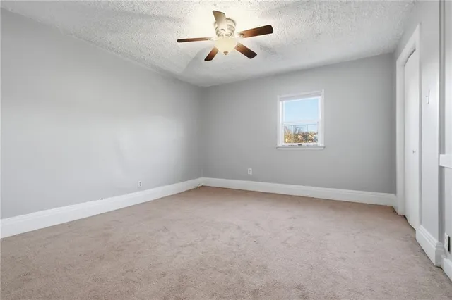 an empty room with a window and a fan