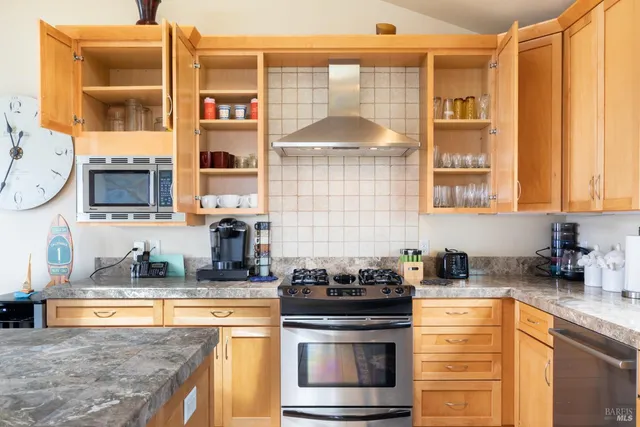 a kitchen with stainless steel appliances granite countertop a stove a sink and a microwave