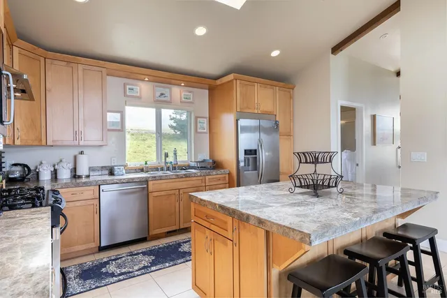 a kitchen with kitchen island granite countertop wooden floors and stainless steel appliances