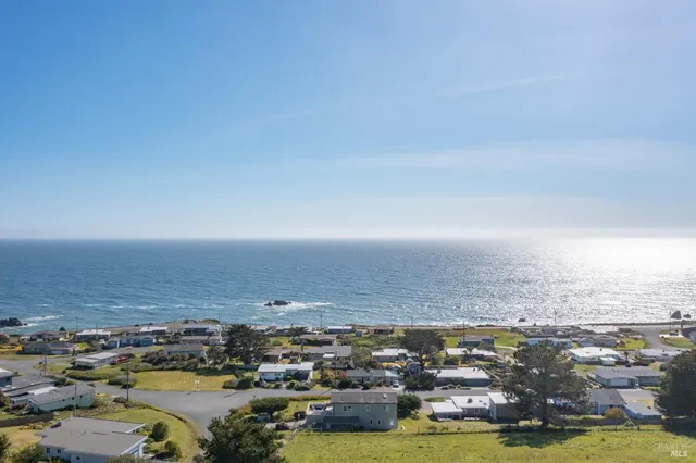 an aerial view of ocean with residential houses with outdoor space