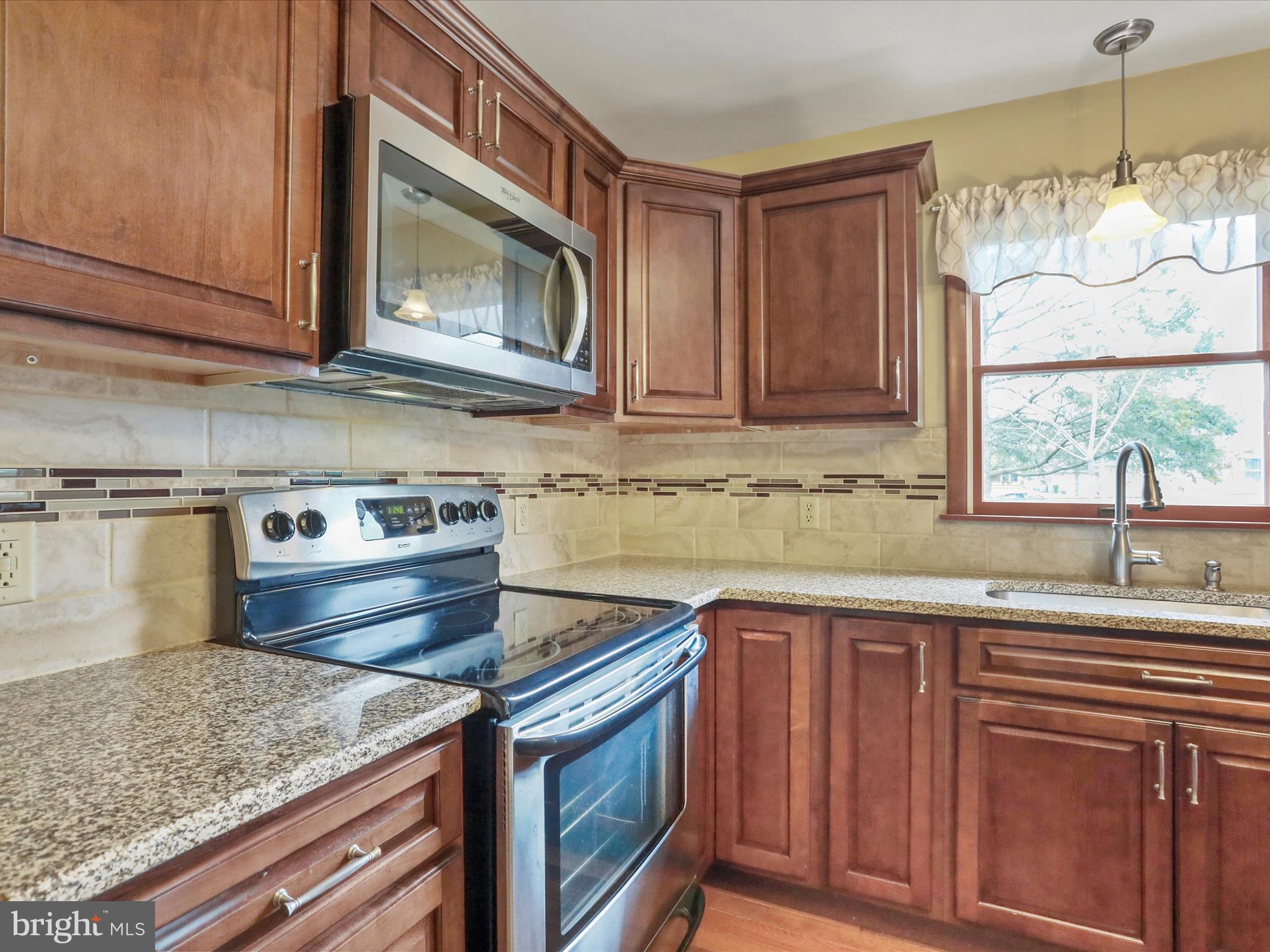 47 Diffys Drive Shippensburg, PA 17257 - Photo 8 of 48 a kitchen with granite countertop wooden cabinets and a stove top oven
