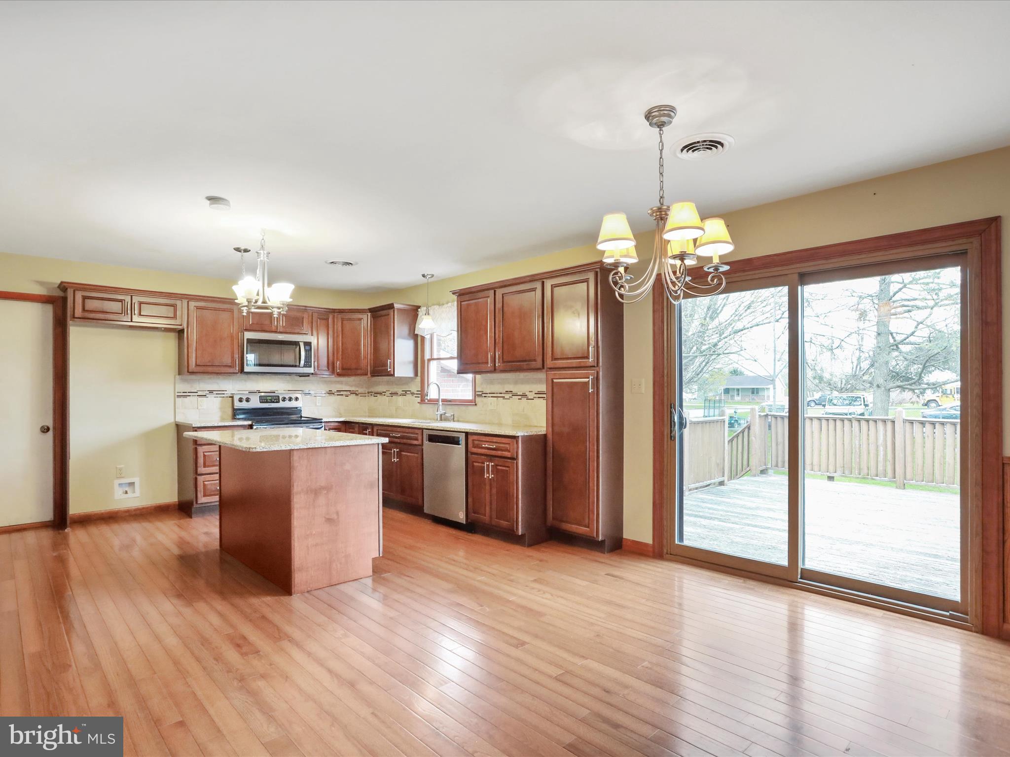 47 Diffys Drive Shippensburg, PA 17257 - Photo 10 of 48 a open kitchen with stainless steel appliances granite countertop a refrigerator a sink dishwasher a stove and a dining table with wooden floor
