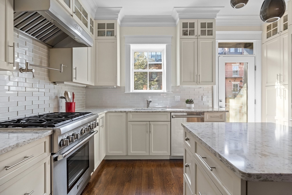 a kitchen with stainless steel appliances granite countertop a sink stove and cabinets