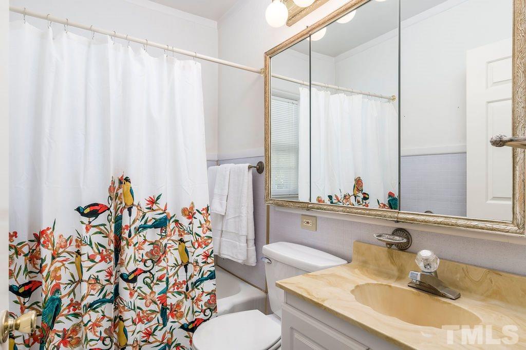 510 Harding Street Raleigh, NC 27604 - Photo 14 of 30 a bathroom with a granite countertop sink and a mirror
