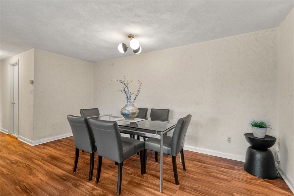 75 Grove Street, Unit 227 Wellesley, MA 02482 - Photo 7 of 29 a view of a dining room with furniture and wooden floor