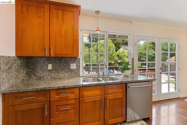 a kitchen with stainless steel appliances wooden cabinets and a large window