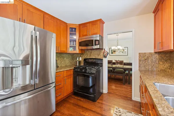 a kitchen with granite countertop a refrigerator stove and oven