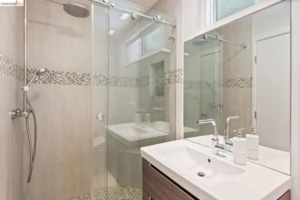 a bathroom with a sink mirror and shower