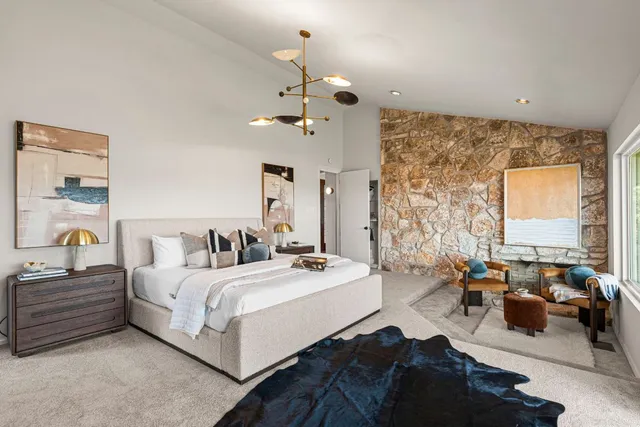 a bedroom with double bed furniture and a chandelier