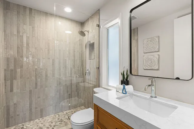 a bathroom with a sink a toilet and shower