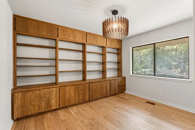 a view of a livingroom with wooden floor and furniture