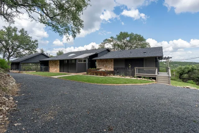 a view of a house with a yard and large tree