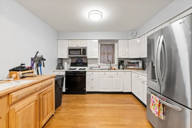 a kitchen with granite countertop a refrigerator stove top oven and sink