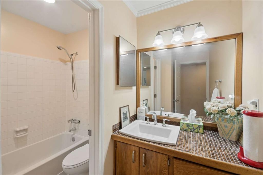 1382 Brockett Place Clarkston, GA 30021 - Photo 12 of 17 a bathroom with a granite countertop sink a toilet and shower