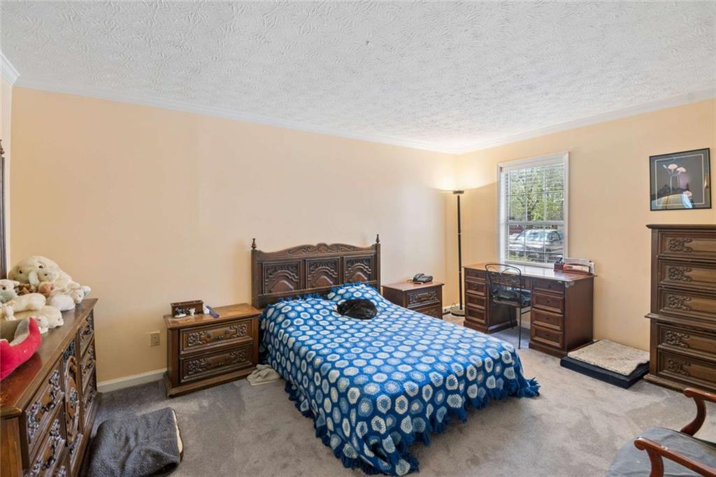 1382 Brockett Place Clarkston, GA 30021 - Photo 14 of 17 a bedroom with a bed and wooden floor