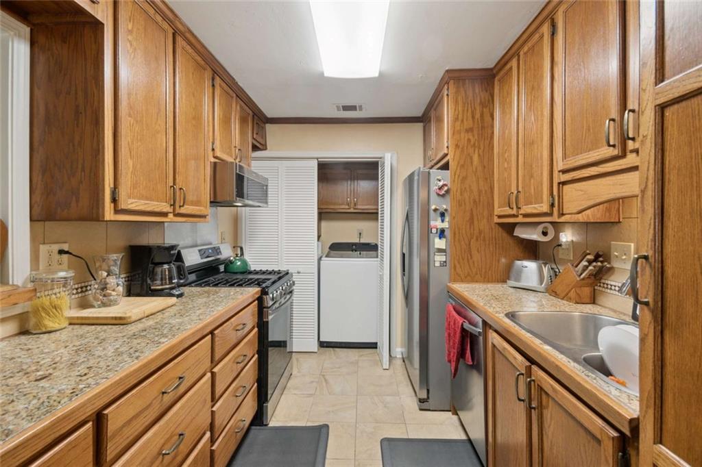 1382 Brockett Place Clarkston, GA 30021 - Photo 6 of 17 a kitchen with stainless steel appliances granite countertop a sink stove and refrigerator