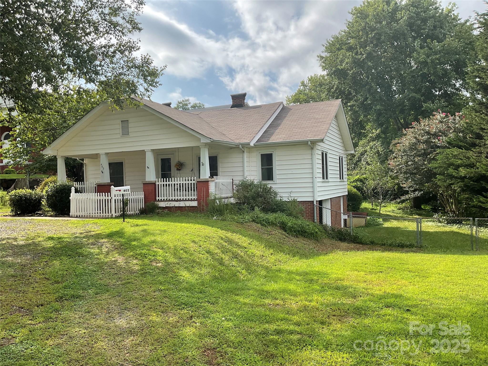 402 Connelly Springs Road Lenoir, NC 28645 - Photo 2 of 33 a view of a house with a big yard potted plants and large tree