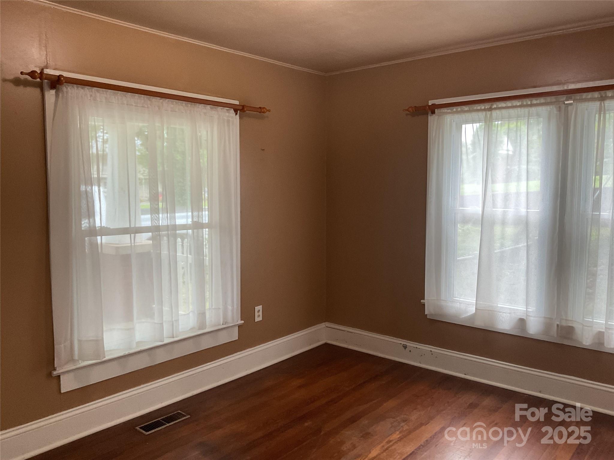 402 Connelly Springs Road Lenoir, NC 28645 - Photo 22 of 33 a view of an empty room with wooden floor and a window