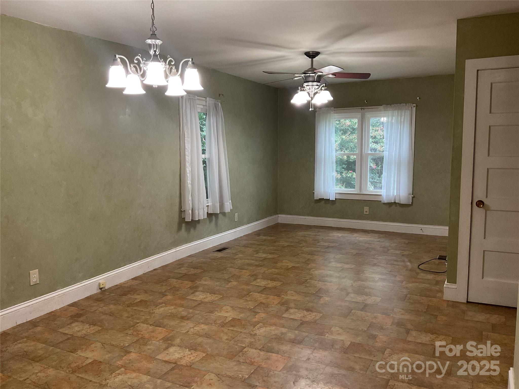 402 Connelly Springs Road Lenoir, NC 28645 - Photo 9 of 33 an empty room with wooden floor chandelier and window