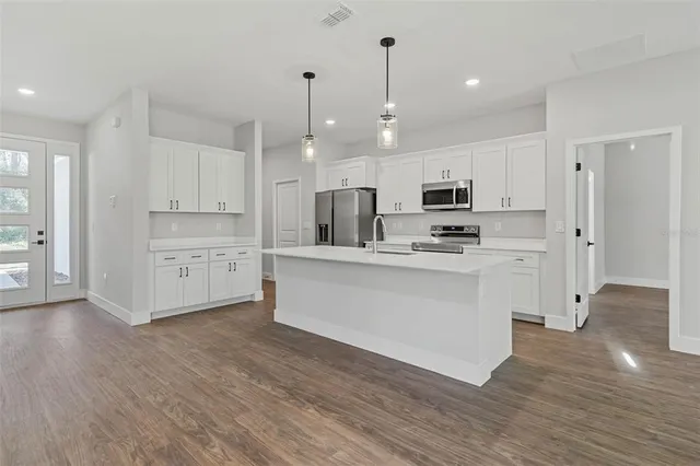 a kitchen with a sink appliances and cabinets