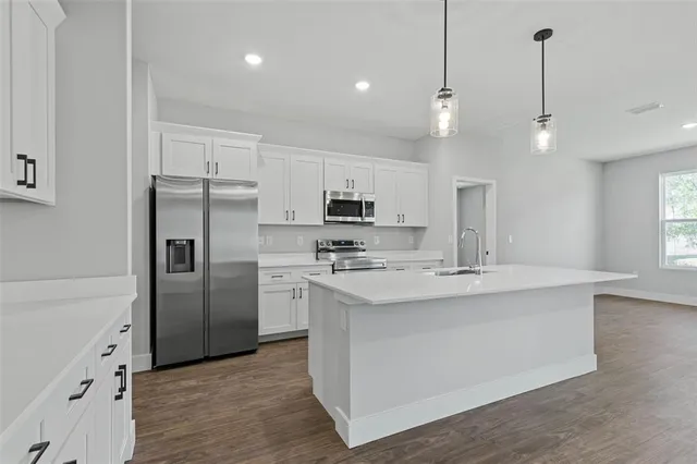 a kitchen with white cabinets and stainless steel appliances