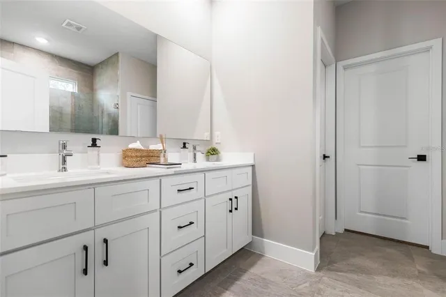 a bathroom with a double vanity sink toilet and mirror