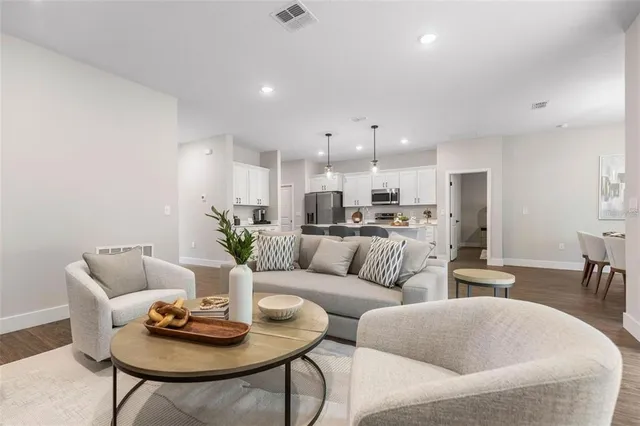 a kitchen with stainless steel appliances kitchen island granite countertop a dining table chairs stove and refrigerator