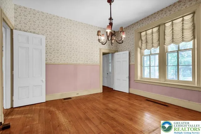 a view of a livingroom with a fireplace wooden floor and a chandelier