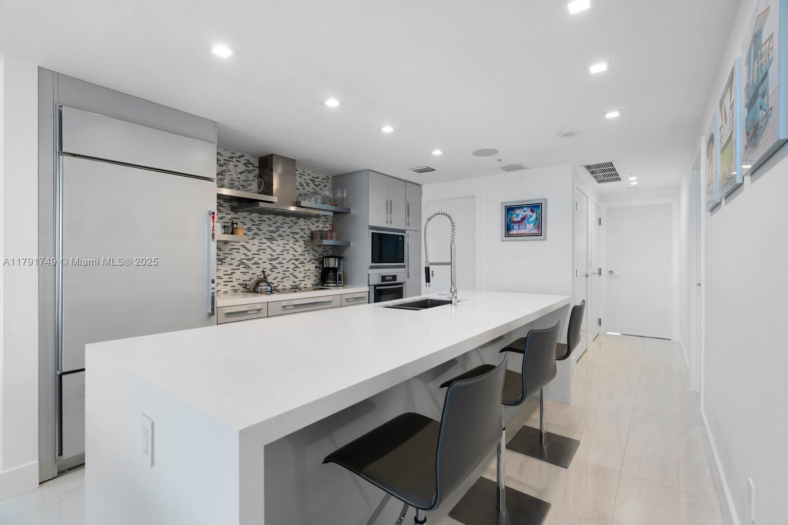3801 Collins Avenue, Unit 703 Miami Beach, FL 33140 - Photo 7 of 20 a kitchen with stainless steel appliances a refrigerator and microwave