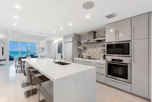 a kitchen with a sink stainless steel appliances and white cabinets