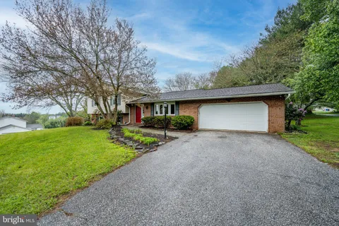 a front view of a house with a yard and trees