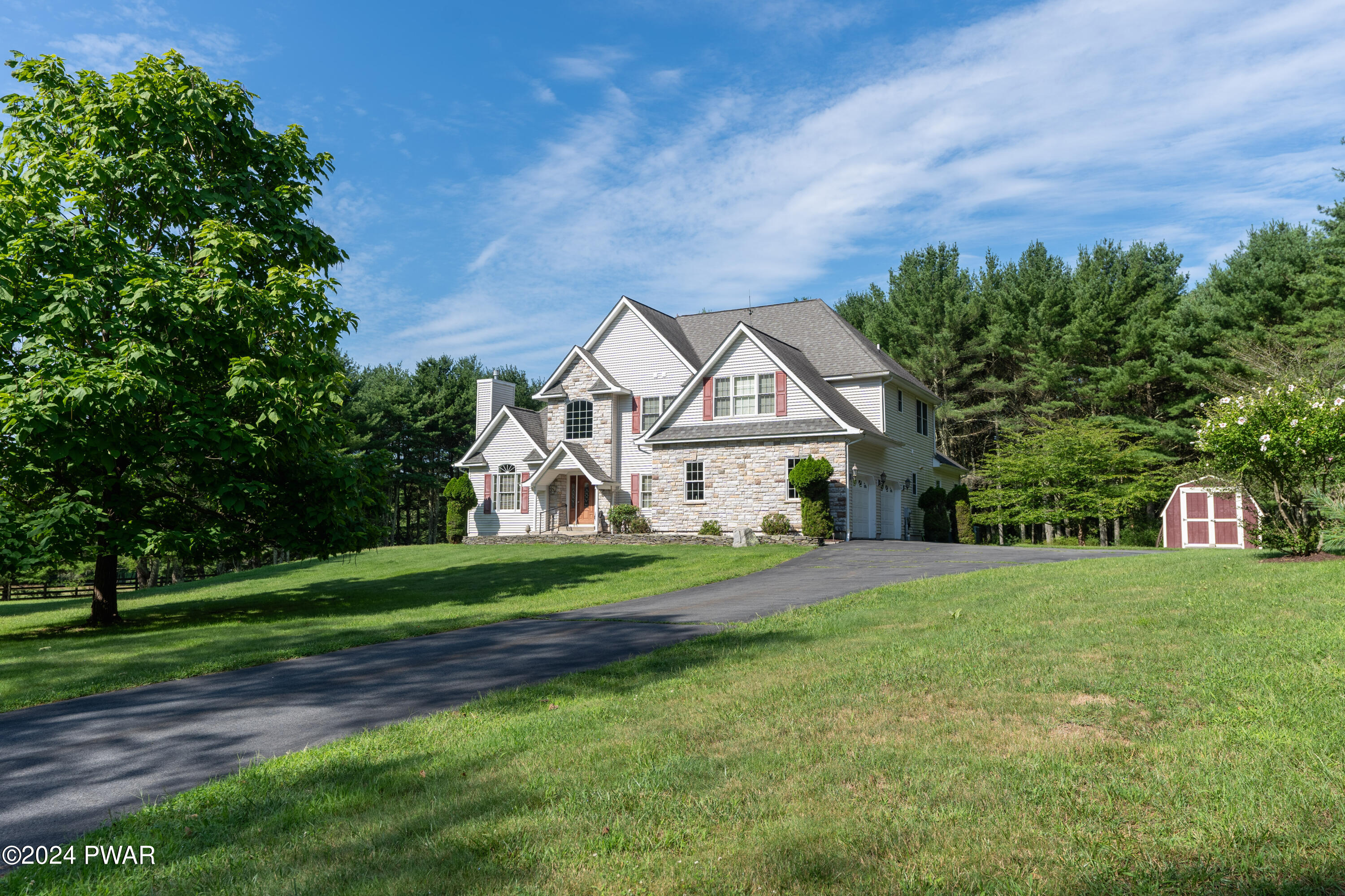 208 Long Meadow Road Milford, PA 18337 - Photo 47 of 64 a front view of a house with a yard and trees