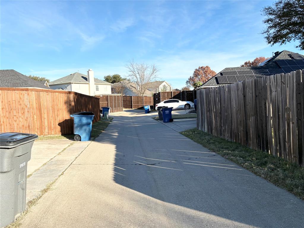 1002 Morningside Lane Allen, TX 75002 - Photo 17 of 18 a view of a patio with couches and table and chairs under an umbrella with large trees