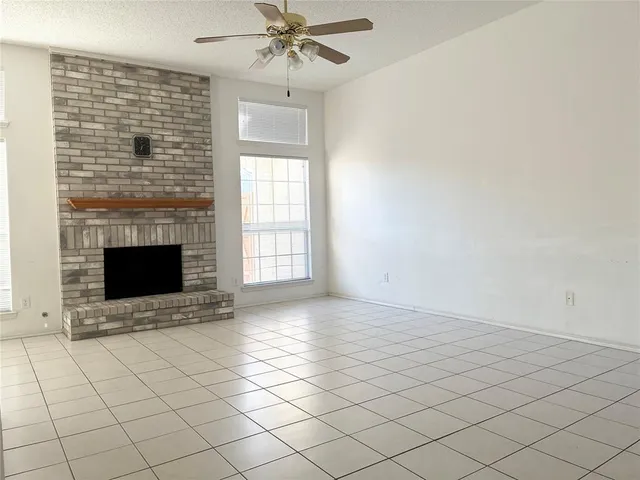a view of an empty room with a fireplace and a window