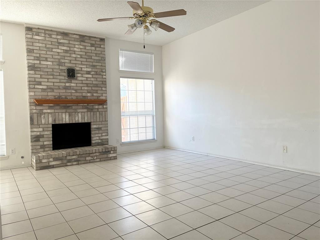 1002 Morningside Lane Allen, TX 75002 - Photo 3 of 18 a view of an empty room with a fireplace and a window