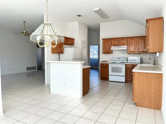a kitchen with stainless steel appliances a stove a sink and white cabinets