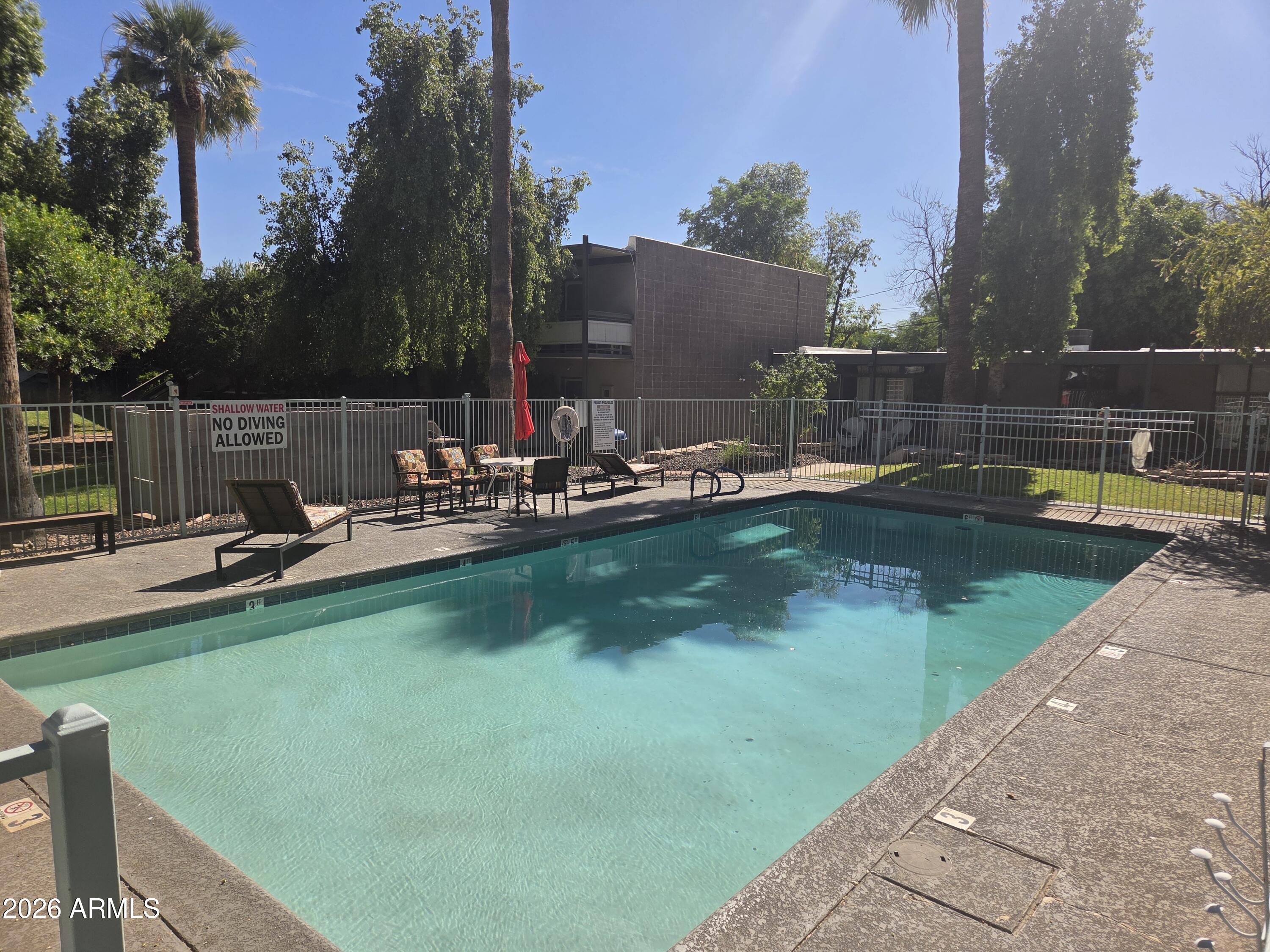 1101 East Bethany Home Road, Unit 7 Phoenix, AZ 85014 - Photo 14 of 14 a view of a lake with a yard and a wooden bench