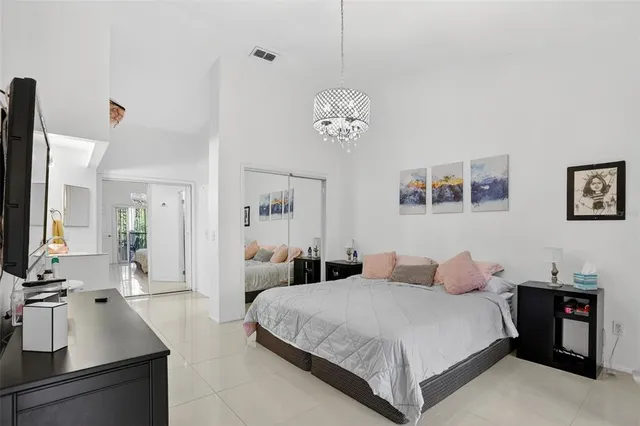 a bedroom with a large bed and a chandelier