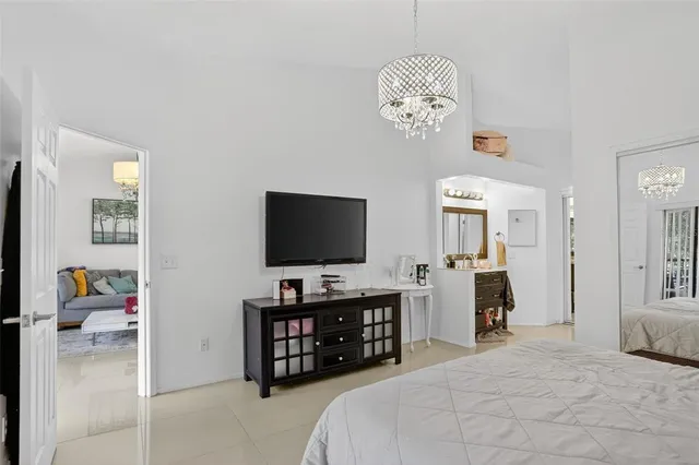 a bedroom with bed and a flat tv screen on dresser