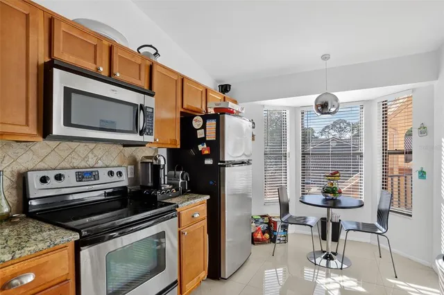 a kitchen with stainless steel appliances granite countertop a stove a microwave and cabinets