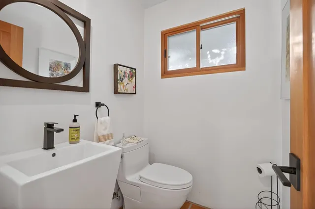 a bathroom with a toilet a sink and a mirror