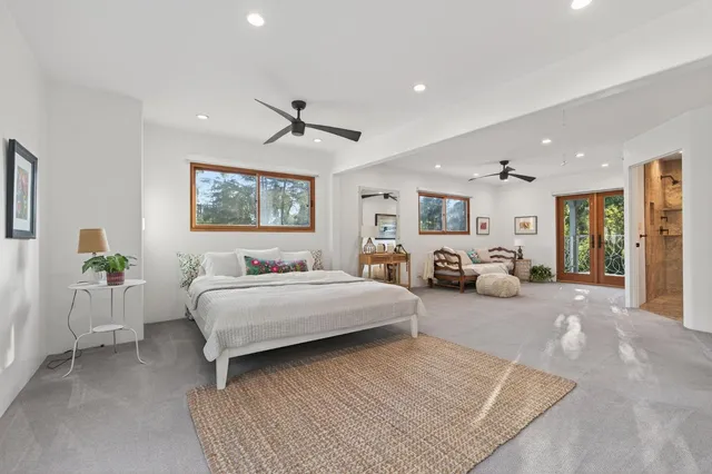 a spacious bedroom with a large bed couch and windows