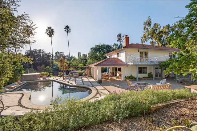 a view of a house with backyard and sitting area